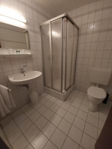 RodewischHotel Garni的带淋浴、卫生间和盥洗盆的浴室