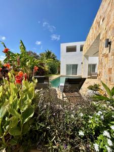 吉汶瓦Tangawizi Villa with Private Pool ZanzibarHouses的一座带游泳池和一些鲜花的房子