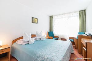 杜劳布拉杜尔酒店的一间卧室配有蓝色的床、椅子和窗户
