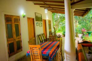 锡吉里亚Travelodge Sigiriya的庭院里配有桌椅的房间