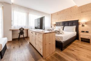 梅扎纳Ravelli Sporting的一间卧室设有一张带木墙的大床