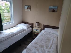 德科克斯多普Chalet duunzicht Texel的一间卧室设有两张床和窗户。