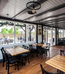 RajkaHotel Rajka的餐厅设有木桌、椅子和窗户。