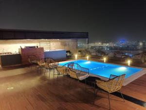 达曼Naviti Warwick Dammam的夜间在建筑物屋顶上的游泳池