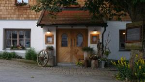 BischofsreutLandhotel zum Matthiasl的前方有木门和轮子的房子
