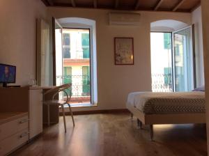 里奥马哲雷美好生活旅馆的一间卧室配有一张床、一张书桌和两个窗户。