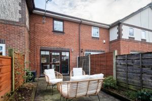 塞尔Very Close to Manchester Airport and Wythenshawe Hospital - Tailored for Monthly and Long Term Stays的一座带藤椅的庭院和一座砖砌建筑