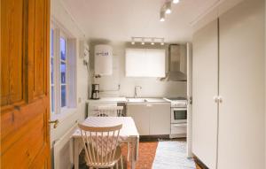 SexdregaSexdrega的带桌椅的厨房以及带白色家电的厨房。