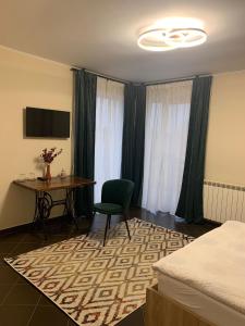 卢戈日pensiunea grecu的酒店客房配有桌子、椅子和书桌