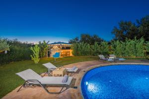 卡拉马孔Romanza Luxury Villa的游泳池周围设有躺椅和椅子