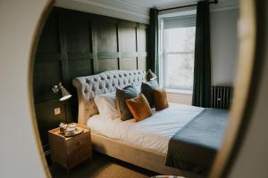GilslandDacre House, Gilsland的卧室配有带枕头的床铺和窗户。