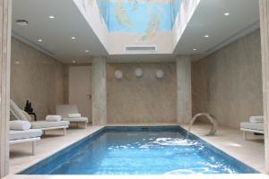 突尼斯Hotel Royal ASBU Tunis的游泳池位于酒店带天花板的客房