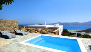 帕诺尔莫斯米科诺斯Sea Breeze Mykonos的一个带两把椅子的游泳池和一个浴缸