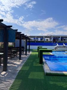 阿夏尔奇亚Al-Ashkhara Beach Resort منتجع شاطئ الأشخرة的一座带游泳池和桌子的度假村和一座建筑