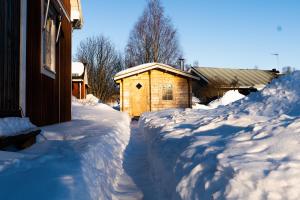 吕勒奥Luleå Village Cabin的一座房子旁边一座有积雪覆盖的院子