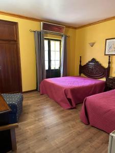 福什科阿新镇金塔多尔德姆旅馆的配有黄色墙壁和木地板的客房内的两张床