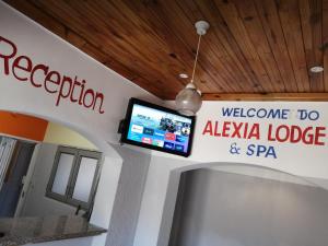 开普敦ALEXIA LODGE & SPA的欢迎入住alaya山林小屋和墙上的spa标志