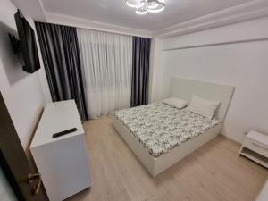 布加勒斯特Oana Luxury Home的一间白色卧室,配有床和电视