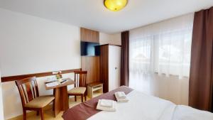 特尔乔夫法特拉酒店的酒店客房带一张床、一张桌子和椅子