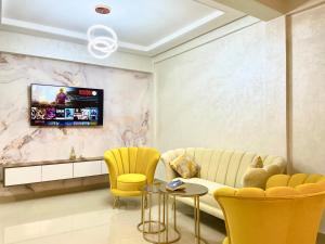 萨菲Most Beautiful Apartment in Safi的客厅配有黄色椅子和墙上的电视