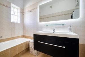 拉夫里翁Sea & Mountain Apartment的一间带水槽、浴缸和镜子的浴室