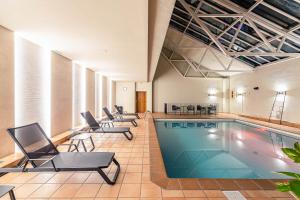 塞奥-德乌赫尔塞奥德乌赫尔旅馆的一个带桌椅的房间的游泳池