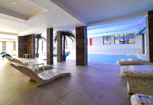 科帕奥尼克Apartman La Foresta Kopaonik的一间带游泳池和一些椅子的客厅