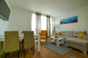 科帕奥尼克Apartman La Foresta Kopaonik的客厅配有沙发和桌子