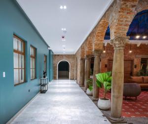 里奥班巴Wanderlot - Hotel Plaza Central的走廊上设有蓝色的墙壁,走廊上设有柱子