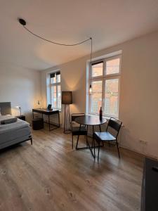 布克斯泰胡德Apartmenthaus Buxtehude St -Petri-Platz Studiowohnung 3的客厅配有桌椅和1张床