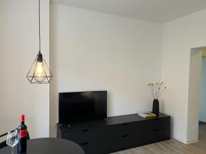 布克斯泰胡德Apartmenthaus Buxtehude St -Petri-Platz Studiowohnung 3的客厅配有黑色梳妆台和平面电视