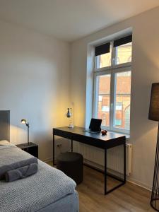 布克斯泰胡德Apartmenthaus Buxtehude St -Petri-Platz Studiowohnung 3的一间卧室配有一张桌子,上面有一台笔记本电脑