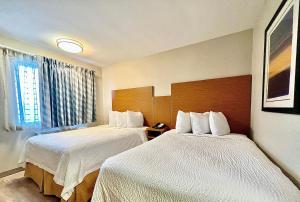 阿林顿阿灵顿六旗温德姆戴斯套房酒店 的酒店客房设有两张床和窗户。