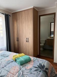 塔尔卡Casa Sector Oriente Talca的一间卧室配有一张带橱柜的床和一间浴室
