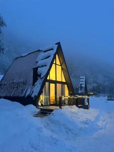 Klek 77 Luxury Chalets near Jahorina的雪中小屋,灯光照亮