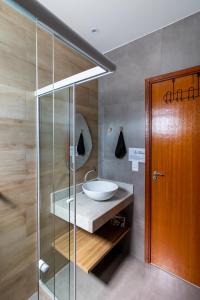 阿拉亚尔-杜卡布Villa Orion的一间带水槽和玻璃淋浴的浴室