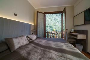 Rocchetta Nervina拉歌宾酒店的一间卧室设有一张床和一个大窗户