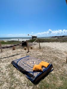 凯博波洛尼奥La Pequeña Hostel的沙滩上铺着毯子