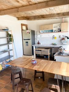 凯博波洛尼奥La Pequeña Hostel的厨房配有木桌和冰箱。