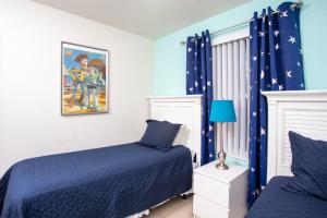 基西米Family Friendly 4 Bedrooms with GameRoom close to Disney in Compass Bay 5103的一间卧室设有两张床和蓝色窗帘