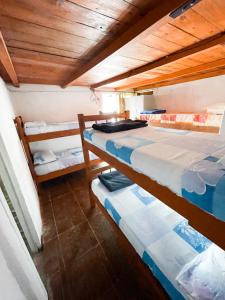 凯博波洛尼奥La Pequeña Hostel的配有木天花板的客房设有两张床。