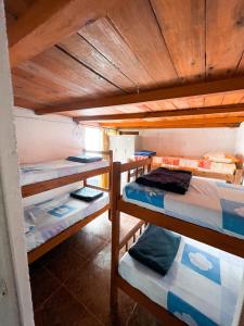 凯博波洛尼奥La Pequeña Hostel的一间设有三张双层床的客房