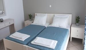 卡尔扎迈纳JP Pool & Apartments的一间卧室配有一张带蓝色床单和白色枕头的床。