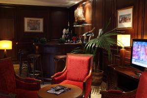 巴黎Amiral Hôtel的酒吧配有桌椅和电视