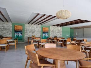 嘎林海斯港Mana Beach Resort Muro Alto Prime - Porto de Galinhas的用餐室配有木桌和椅子