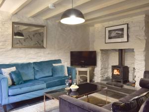 贝图瑟科伊德2 Banc Llugwy的客厅设有蓝色的沙发和壁炉