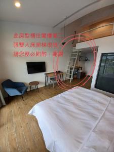 埔里埔里隱巷人文行旅民宿的卧室配有白色的床和红色软管