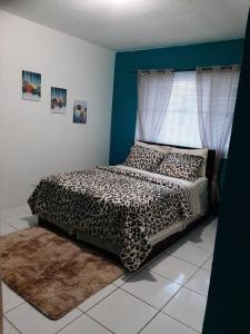 拿骚Seashells的一间卧室配有一张带窗户的豹纹床