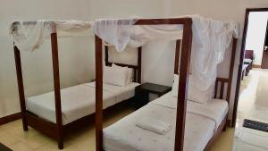 HuuAman Gati Hotel Lakey的卧室配有2张双层床和白色床单