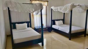 HuuAman Gati Hotel Lakey的卧室配有2张双层床和白色床单